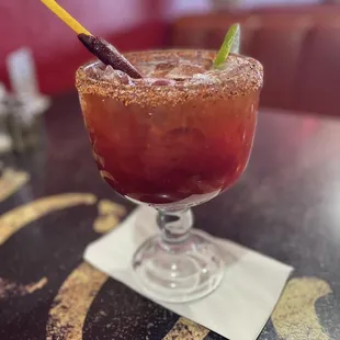 a bloody cocktail with a lime garnish