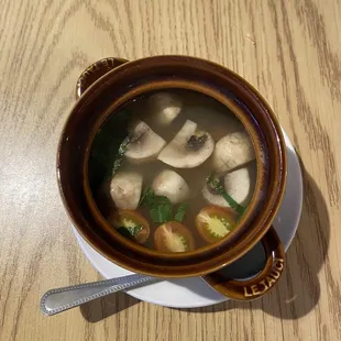 a bowl of soup with mushrooms and broccoli