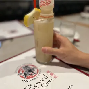 a person holding a drink on a table