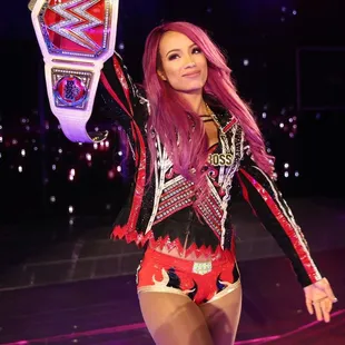 a female wrestler holding up a wrestling belt