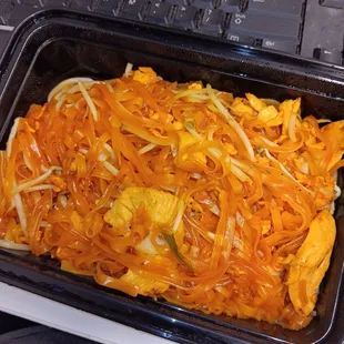 a tray of noodles and carrots