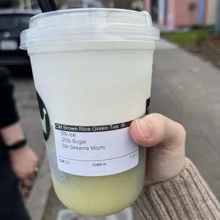 a person holding a cup of iced coffee