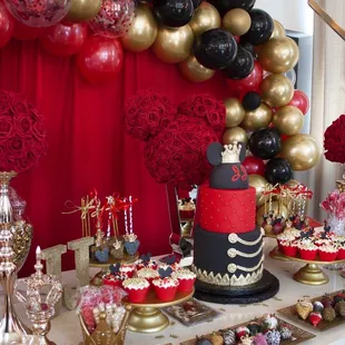 a dessert table with red and gold decorations