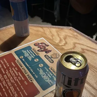 a can of beer and a menu