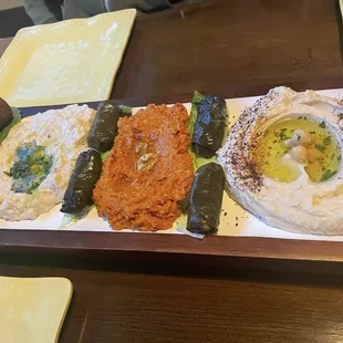 Sampler: Hummus,  Muhammara, Baba Ghanouj served with pita, grape leaves stuffed with rice, falafel