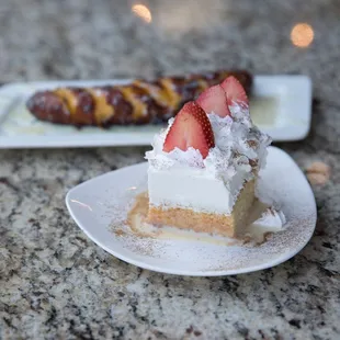 a plate of dessert with strawberries and a pretzel