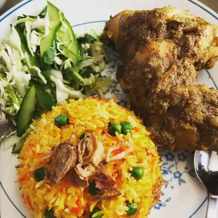 a plate of rice, meat and vegetables