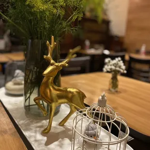 a gold deer statue and a birdcage