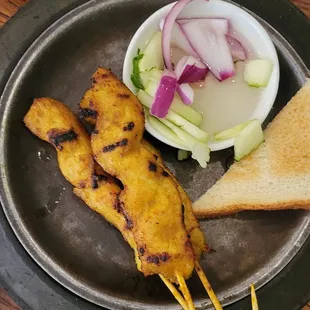 Chicken Satay served with toast, pickled cucumbers and onions and sweet peanut sauce
