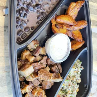 Porchetta platter with sweet plantains, black beans and slaw