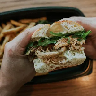 a person holding a sandwich