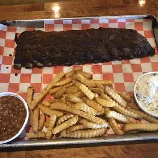 A Full Slab of Ribs with Baked Beans, Fries, and Potato Salad