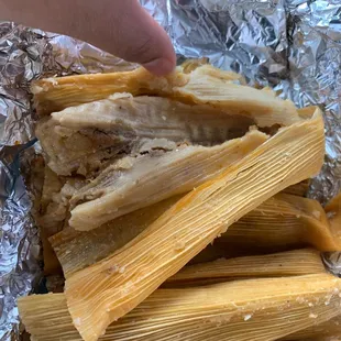a hand reaching for the tamales