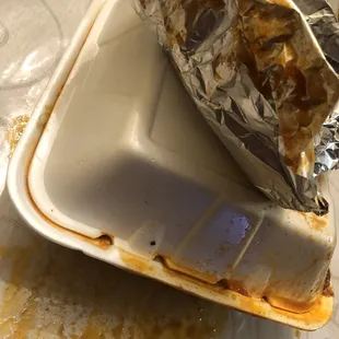 a half eaten sandwich in a styrofoam container