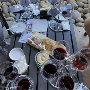 a table with wine glasses and cheese board