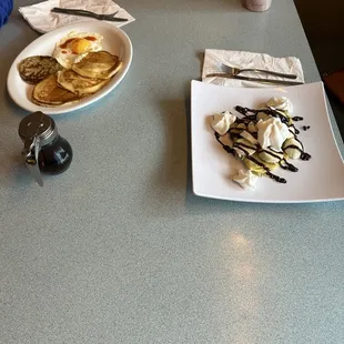 Banana and Nutella crêpe with chocolate and whip whipped cream on top.  Also, pancakes with syrup, sunny side up egg, and sausage.