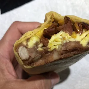 Breakfast burrito with bacon, beans, cheese and eggs.
