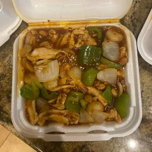 a takeout container of chicken and vegetables