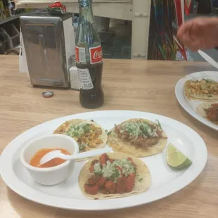 a plate of tacos and a bottle of soda