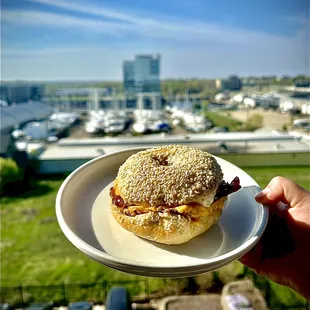 Bacon egg and cheese Sandwich on a sesame bagel with green onion and cheddar cream cheese