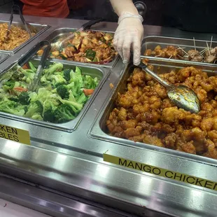 a variety of food being served at a buffet