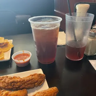 Small cup: Buffalo sauce, Middle cup: plastic to go cup, third cup to right: hard plastic restaurant cup with unsweet iced tea.