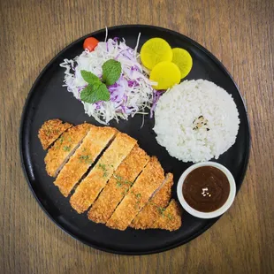 a plate of food with rice, meat, and vegetables