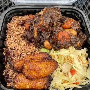 Oxtails with rice and peas, cabbage, and plantains