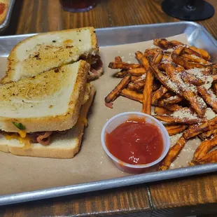 a tray of fries and a grilled cheese sandwich