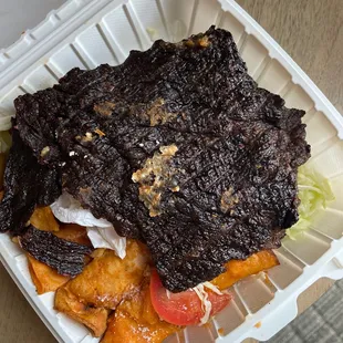 a beef sandwich in a styrofoam container