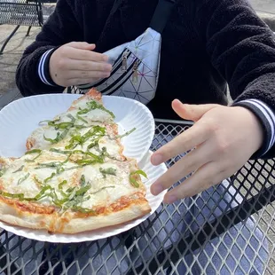 Her white pie slice - the premade slices already have red sauce but it was still good@