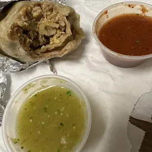 Sausage breakfast burrito with green and red salsa
