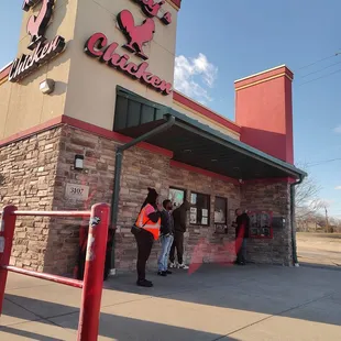 people standing outside of a restaurant