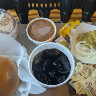 Pulled pork sandwich with banana pudding, baked beans, soda, and self-serve pickles and onions