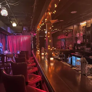 a bar with red chairs