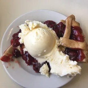 a piece of pie with ice cream and cranberry sauce