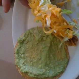Meat taco, tostada with guacamole.