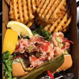 Lobster roll served with waffle fries.