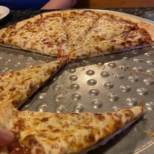 a person grabbing a slice of pizza