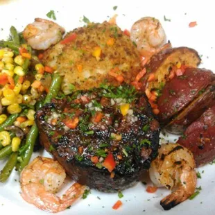 a plate of steak, shrimp, and vegetables