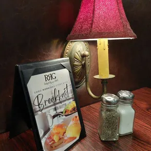 a table with a menu and a lamp