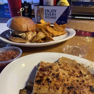 Quesadilla (half, bitten into) and Chicken pesto sandwich and fries