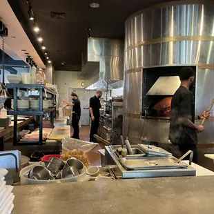 Inside the restaurant in front of the brick oven