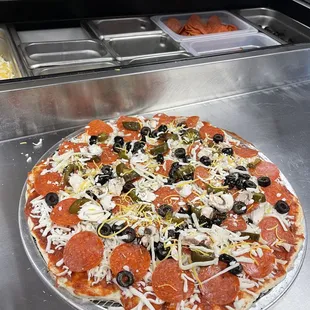 a pizza with pepperoni, olives, and cheese