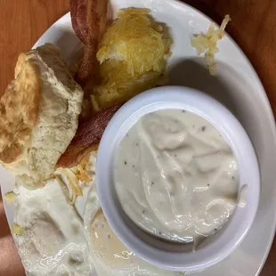 Two egg plater. Eggs over easy with bacon, hash browns and biscuits and gravy.