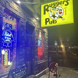 a neon sign for ruggers pub