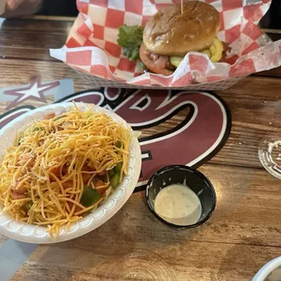 Breaded chicken sandwich with teriyaki sauce and a salad for the side.
