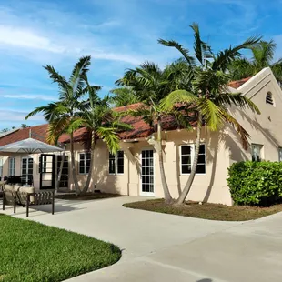 the front of a house with palm trees