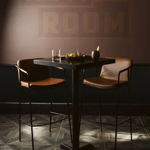 a table with two chairs and a bowl of fruit