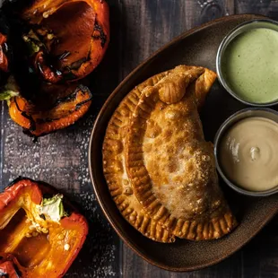 a plate of empanadas with dipping sauce